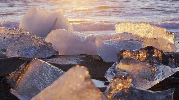 冰岛的钻石海滩日落时在黑色火山沙上闪闪发光的冰山日出时被海浪撞击的清晰的冰川冰块欧洲的旅游胜地拍摄8K分辨率4320p