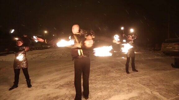 令人惊奇的部落篝火表演舞蹈在冬天的夜晚在飘落的雪舞团在雪天以火炬和烟火表演