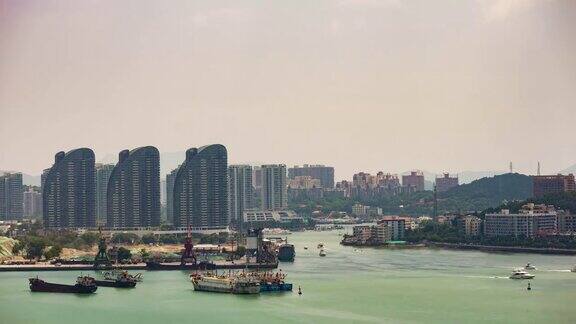 阳光明媚的一天海南三亚建设湾公寓综合楼全景4k时间推移中国