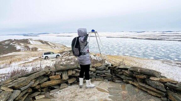 女人在贝加尔湖冰面上的旅行闭关独特的佛塔布尔可汗纪念碑象征神秘的历史仪式岛大井山水山萨满教崇拜冬岛之旅