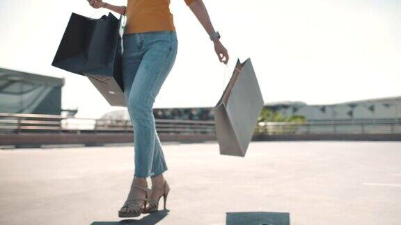 自信的女人走在购物中心购物袋