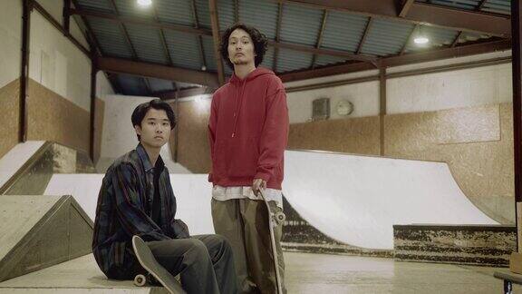 两名日本男性滑板运动员在滑板公园的肖像(慢镜头)