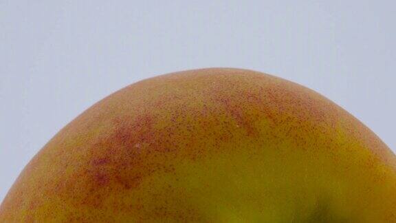 整个桃子的超近宏在转盘上旋转孤立在白色背景上