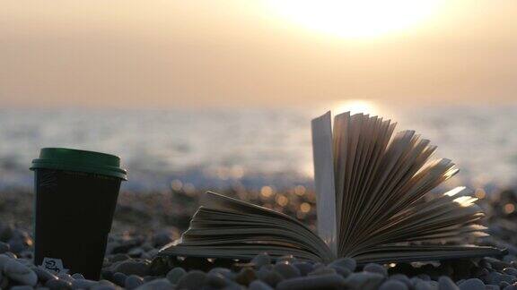 一杯咖啡和一本书以大海为背景