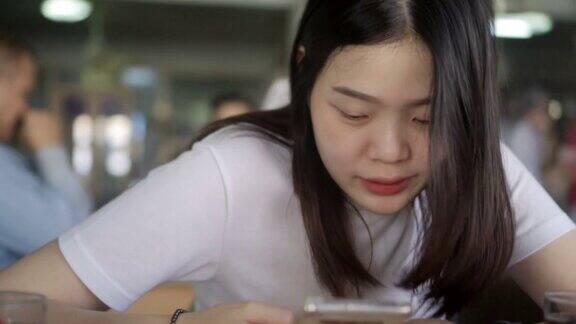 亚洲女性坐着使用智能手机