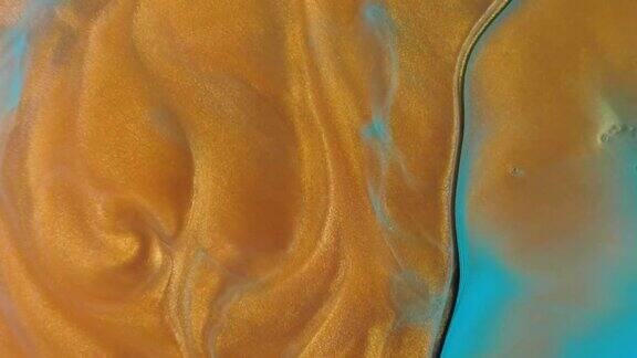 彩色的金色沙子在彩色的液体中有机地移动