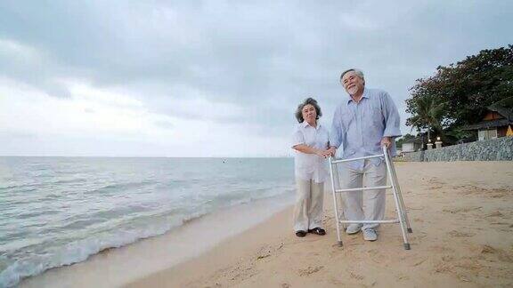 老人在沙滩上与walker和他的妻子一起锻炼人有医疗、医疗和退休