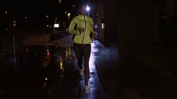 SLOMOTS一名女子在雨夜的街道上奔跑