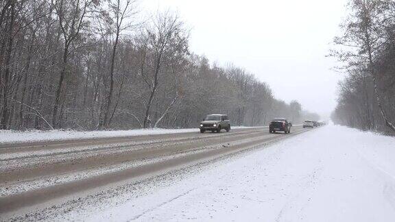 暴风雪期间冬日路上的汽车