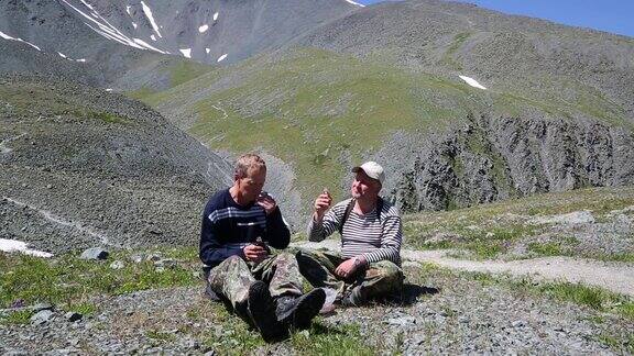 两个游客在山上喝酒吃饭