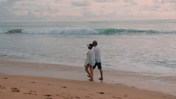幸福的情侣一起走在沙滩上