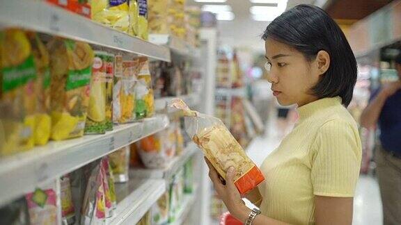 年轻的亚洲女人在杂货店买食物
