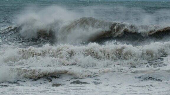 暴风雨的波暴风雨中带着泡沫和泥土的大浪拍打着海岸
