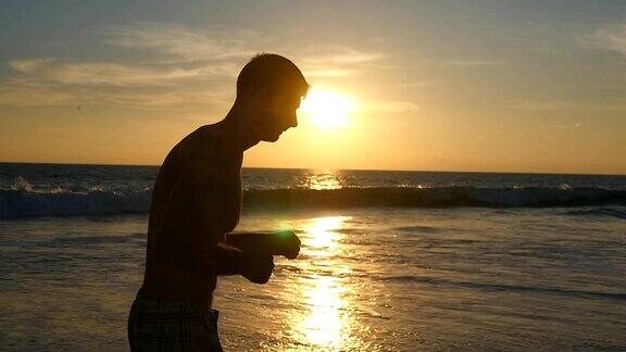 日落时分年轻的运动员在海滩上跑步一个运动健将在日出时沿着海岸慢跑户外运动的男运动员健康积极的生活方式在自然的锻炼慢动作