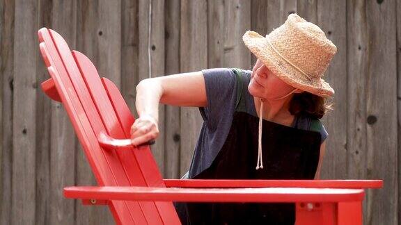 一个成熟的女人在自家后院画沙滩椅