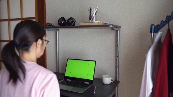 女人在家里开视频会议用笔记本电脑的彩色键屏