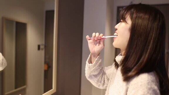 年轻女子在酒店房间刷牙