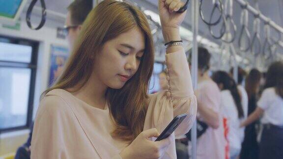 年轻女子在曼谷的火车上发短信