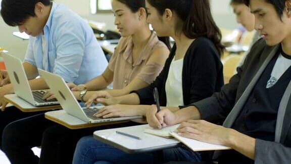 亚洲大学生正在教室里学习和使用笔记本电脑