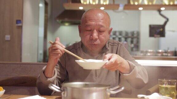 中国的老人正在吃火锅