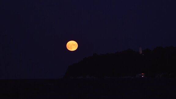 满月在海边的灯塔升起