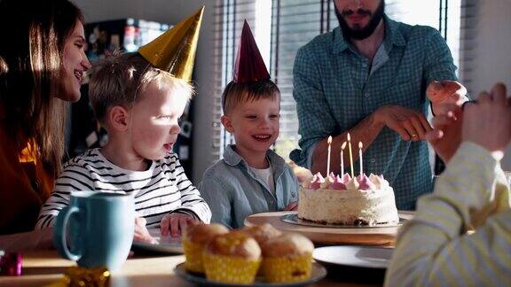 年轻的父亲为小白种人儿子带来生日蛋糕在家里用家庭慢镜头庆祝有趣的聚会