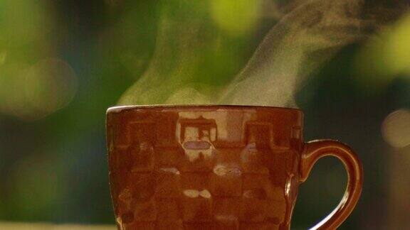 4k热腾腾的蒸意式咖啡特写棕色茶杯与阳光背景热饮概念
