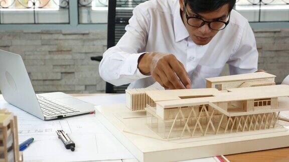 建筑师正在用笔记本电脑检查他的建筑模型
