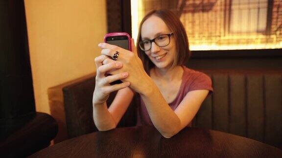 漂亮女孩用智能手机自拍做鬼脸很有趣