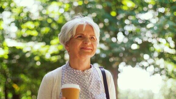 一位老妇人在公园散步喝着咖啡