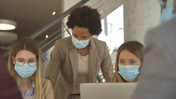集团商务人员在办公室开会和工作戴口罩以防止冠状病毒