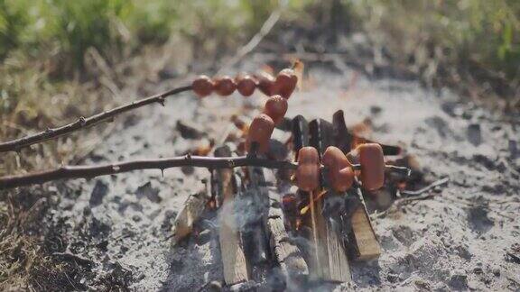 在篝火上烤肥香肠捷克乡村流行的户外活动在篝火旁煮香肠