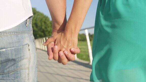 特写:新婚夫妇手牵着手在公园里浪漫散步