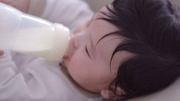在家里用奶瓶喂亚洲男婴