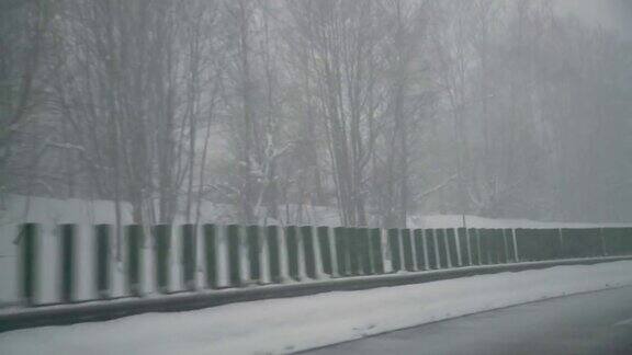 暴风雪期间汽车在光滑的柏油路上行驶危险驾驶条件