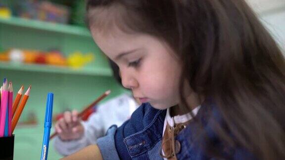 学龄前儿童在教室里在书上画画