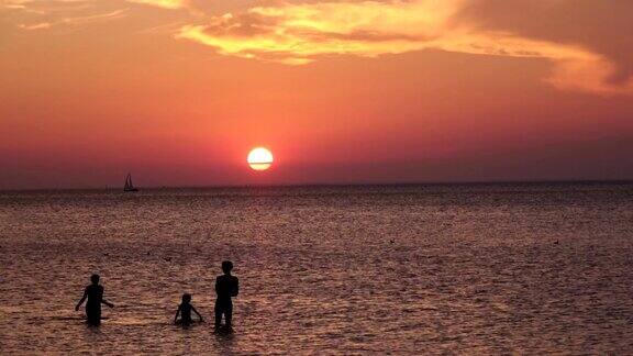 夏日海面上夕阳下的人影