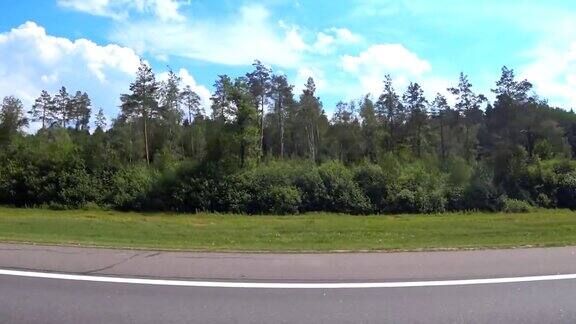 从公路上一辆快速行驶的汽车的窗口看到的森林