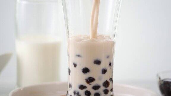 将奶茶倒入饮用杯中加入台湾流行的珍珠泡
