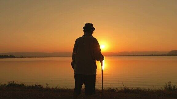 快乐时光老亚男在湖边欣赏日落慢镜头