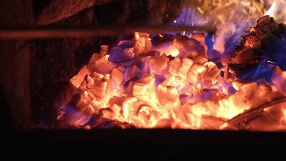 壁炉里燃烧木头的特写从壁炉拨火棍下迸出火花