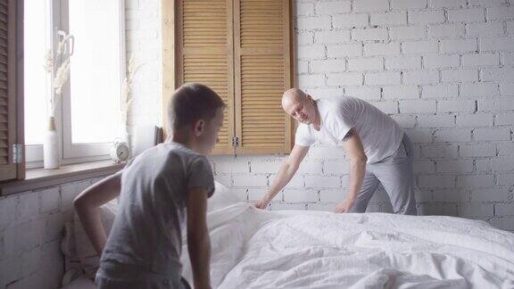 父亲和儿子在早上铺床