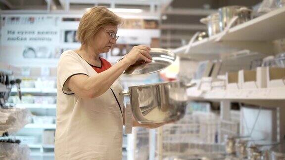 一位成年妇女从柜台上拿了一个平底锅这位女士想用她煮汤