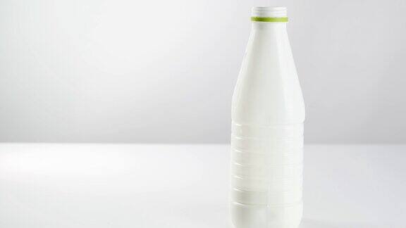 白色背景的塑料瓶里的乳制品玻璃烧杯里的酸奶酸乳酒