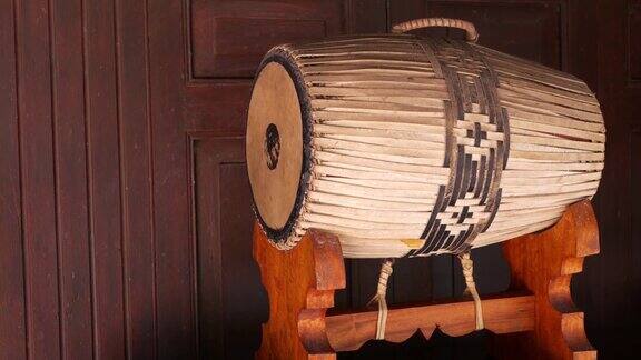 传统的鼓站传统的泰国鼓装饰放置在木架上靠近木墙