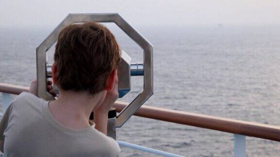 男孩用双筒望远镜看海