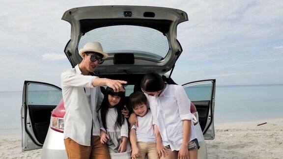 快乐的亚洲家庭四人在暑假汽车旅游和假日概念