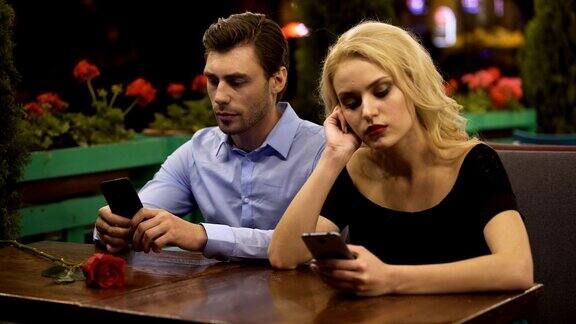 两个年轻人无聊的约会使用智能手机关系问题