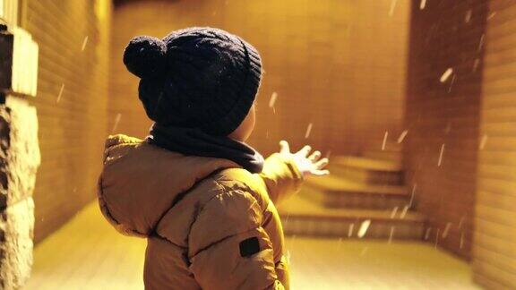 学前班的男孩晚上在雪地里玩