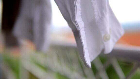 衣服衬衫洗衣细节是干在晾衣绳上和摇摆在轻微风电影的dof